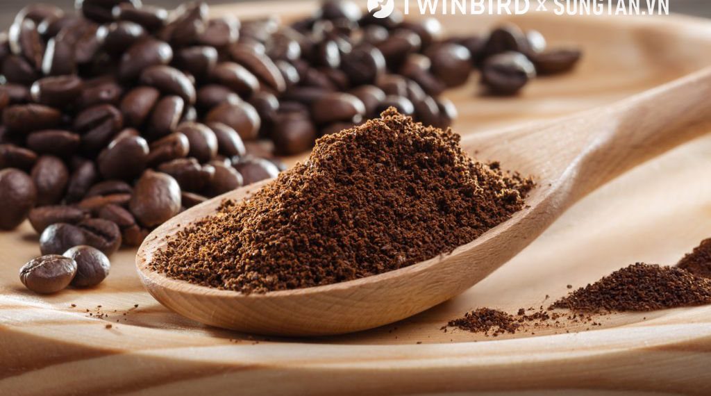 Ground coffee in wooden spoon. Coffee fried grain on wooden platter. Close-up. Coffee ground, coffee beans.